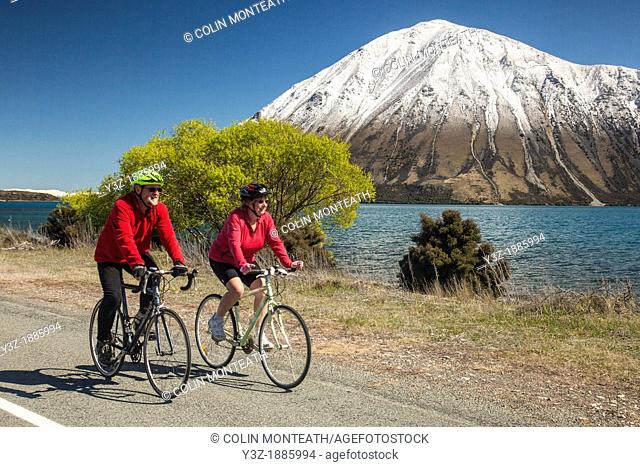 Cyclists enjoys spring conditions on back roads Lake Ohau, Mackenzie country, Canterbury, New Zealand not for sale to cycle industry