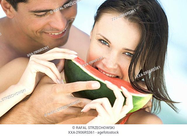 couple eating watermelon on beach