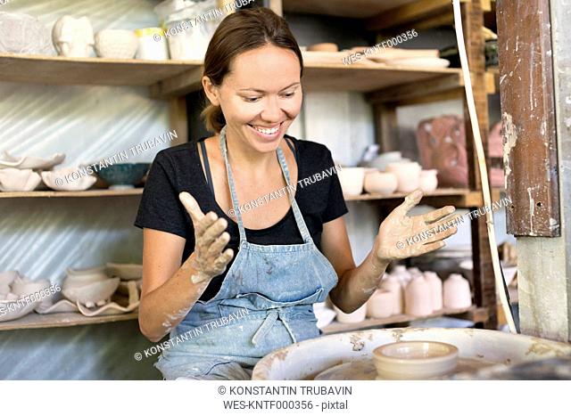 Smiling woman working in pottery