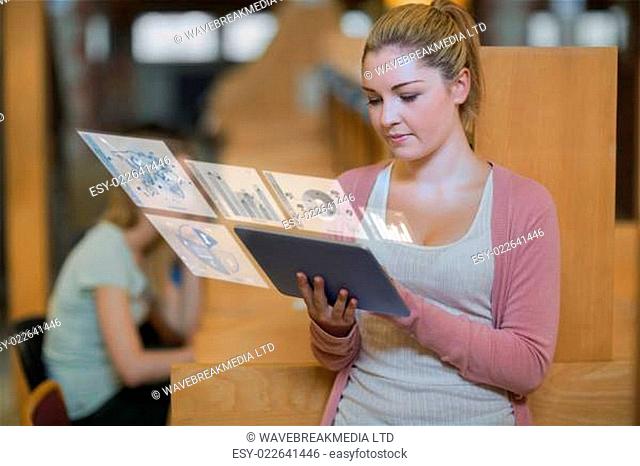 Pretty blonde student working on her digital tablet