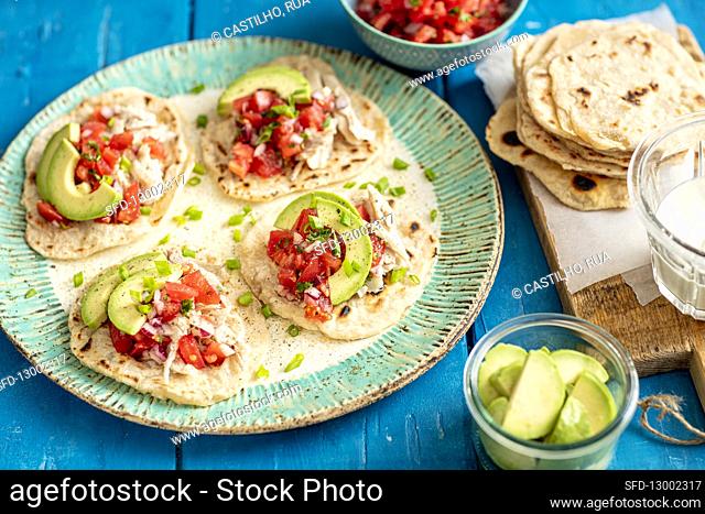 Home made tortillas with shredded cooked chicken, avo and tomato salsa