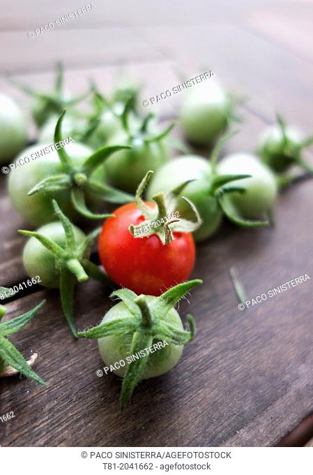Green and red cherry tomatoes on wooden table
