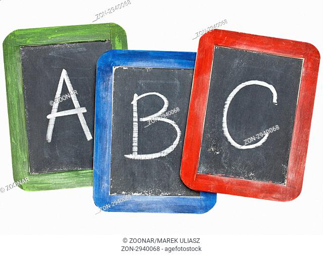 first letters of alphabet A, B, C in white chalk handwriting on three small slate blackboards