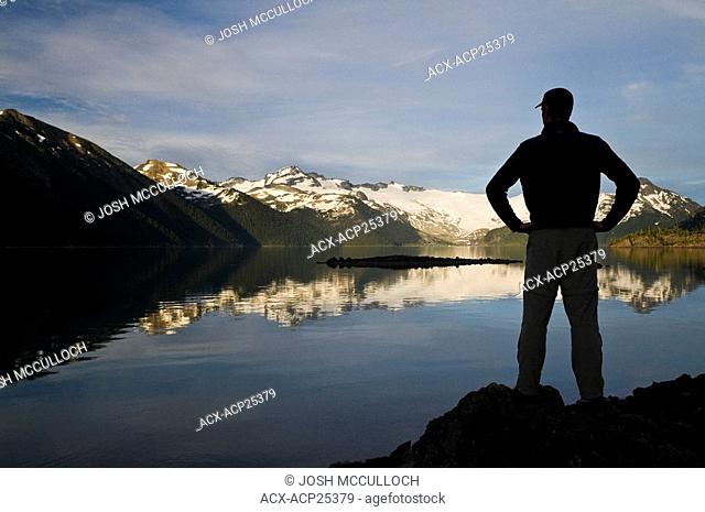 A hiker is silhouetted by the Sphinx Glacier at Garibaldi Lake in Garibaldi Provincial Park near Whistler BC