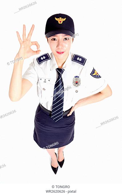 Young smiling female police officer with okay sign