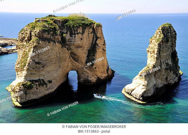 Excursion boat off the Pigeons Rock, Grotte aux Pigeons, limestone rocks eroded by wind and weather in the Raouche district, Beirut, Lebanon, Middle East, Asia