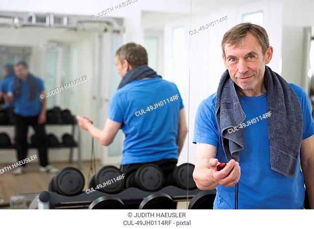 Trainer holding stopwatch in gym