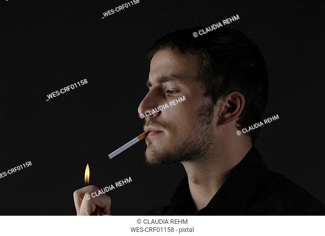 Man lighting a cigarette, portrait