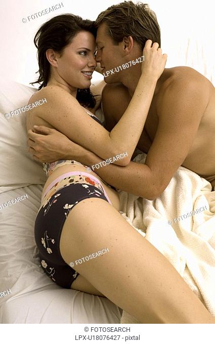 Portrait of an attractive couple snuggling in bed