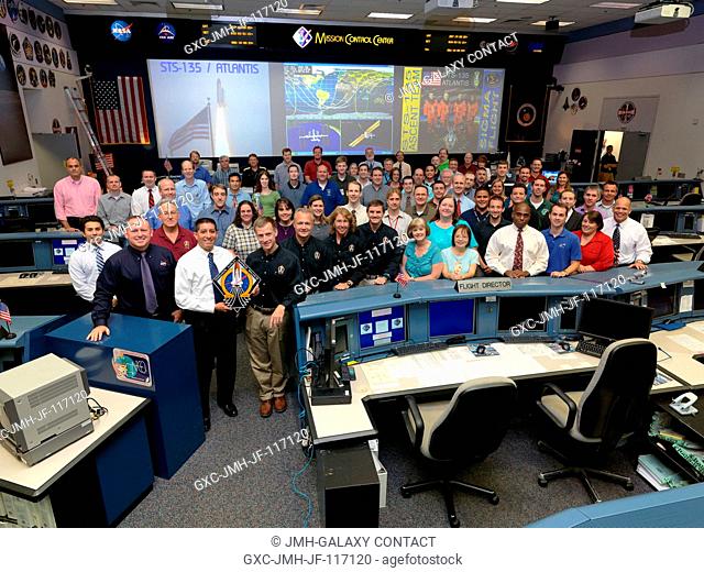 The members of the STS-135 Ascent flight control team and crew members pose for a group portrait in the space shuttle flight control room in the Mission Control...
