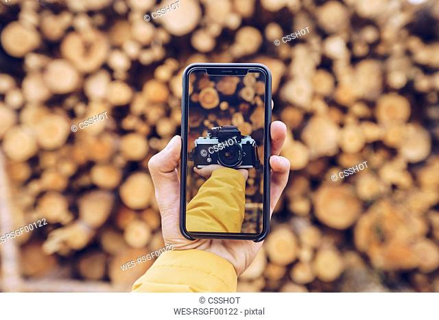Hand holding smartphone with a picture of a camera