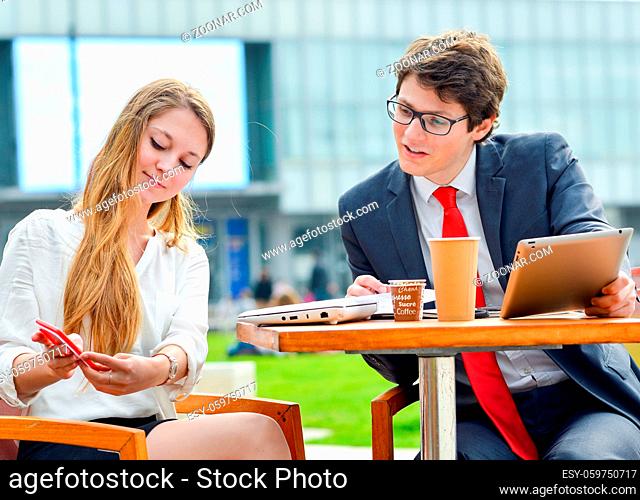 Young executive doing planning with business team outdoors at a table