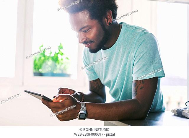 Young man using his phablet at home