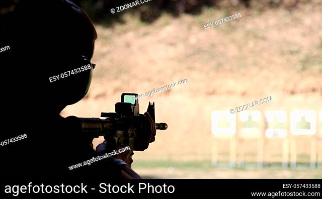 Military man shoots targets with a machine gun