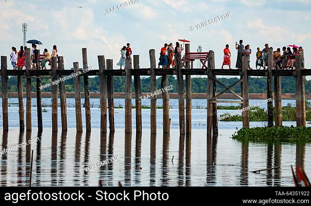 MYANMAR, AMARAPURA - OCTOBER 25, 2023: Tourists are seen on the U Bein Bridge spanning Lake Taungthaman. The 1.2-kilometre bridge is believed to be the world's...