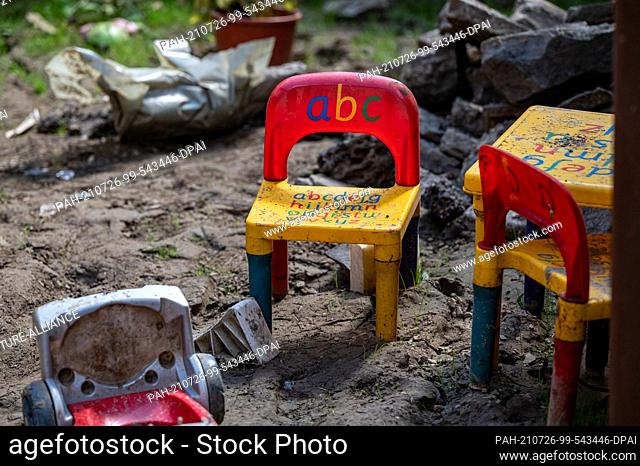 26 July 2021, North Rhine-Westphalia, Altena: A children's seating group and toys lie in a garden. The village in Sauerland was temporarily inaccessible after...
