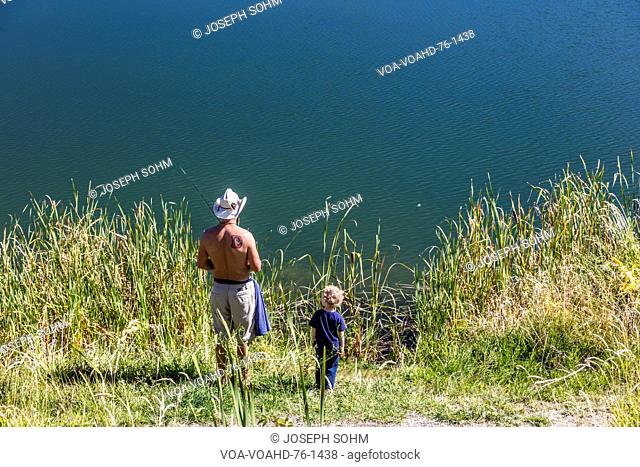 Father and son are fishing South of Montrose Colorado, off the Uncompahgre, on Chipeta Lakes, Montrose, Colorado. September, 26, 2016