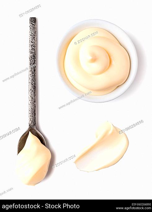 Bowl and spoon with mayonnaise isolated on white background