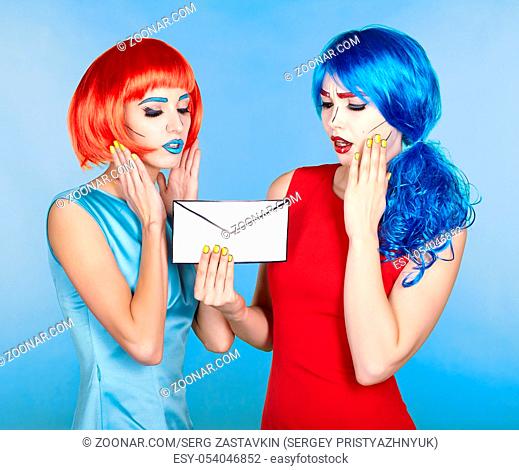 Portrait of young women in comic pop art make-up style. Females in red and blue wigs and dresses are reading letter