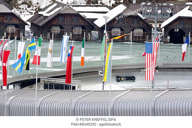 The four-person Bob with Nick Cunningham and his team from the USA on the echo-curve lined with flags in Schoenau Am Koenigssee, Germany, 22 February 2017
