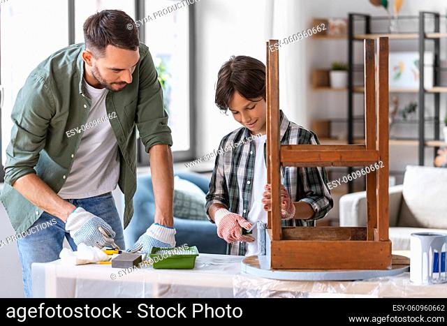father and son painting old table in grey color