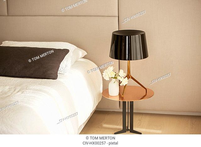 Lamp and rose bouquet on bedside table