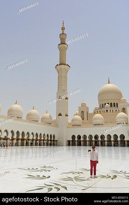 A tourist taking a selfie in the inner courtyard of Sheikh Zayed Mosque. Abu Dhabi. United Arab Emirates
