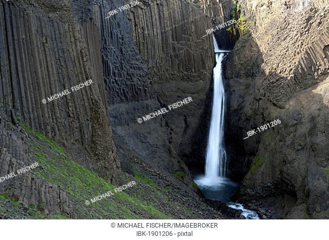 Litlanesfoss waterfall framed by columns of basalt, Iceland, Europe