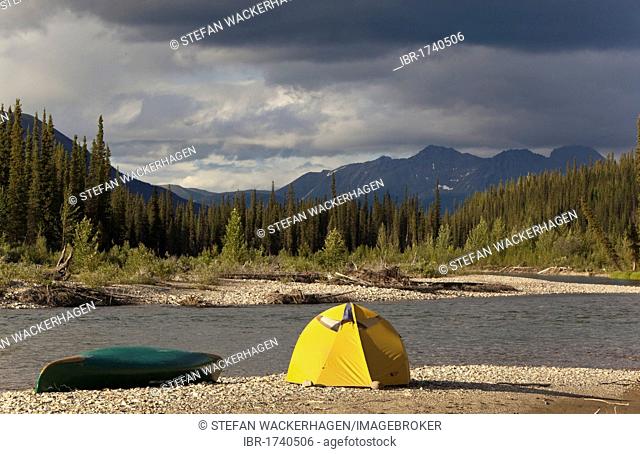Camp on gravel bar, tent and canoe, Pelly Mountains behind, upper Liard River, Yukon Territory, Canada