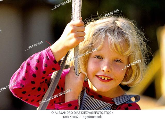 Girl swings and smiling