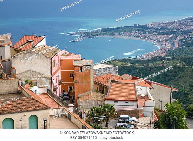 The roofs of houses in Castelmola town in the Province of Messina in the Italian region Sicily. View with Giardini Naxos town on background