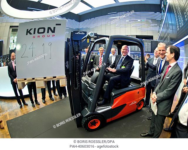 Gordon Riske (C), head of German multinational manufacturer of forklifts Kion, poses for the camera with a forklift on the floor of the Stock Exchange in...