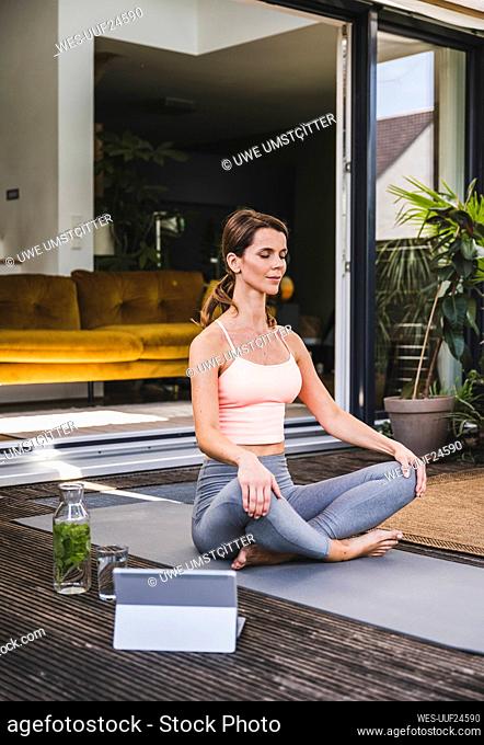 Woman meditating while exercising on terrace