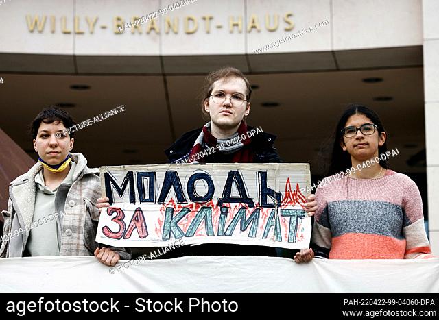 22 April 2022, Berlin: Ilyess El Kortbi (M), Ukrainian activist of the organization Fridays For Future, holds a poster with the translated inscription ""Youth...
