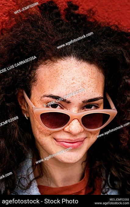 Beautiful smiling young woman wearing sunglasses