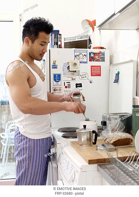 Man in kitchen making coffee
