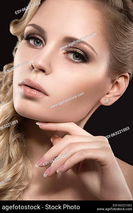 Beautiful blonde girl with perfect skin. Picture taken in the studio on a black background