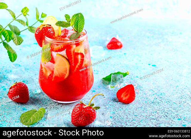 Refreshing drink with fresh slices of strawberries, lime and mint leaves. Copy space. Concept of summer homemade drinks