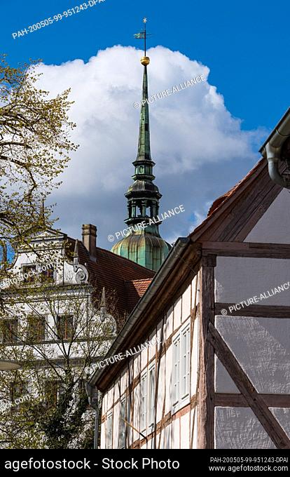 14 April 2020, Brandenburg, Doberlug-Kirchhain: One of the towers of the City Castle above the roof of a house. The Renaissance castle has seen several owners...
