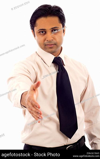 Serious looking Indian businessman offering a handshake isolated over white background