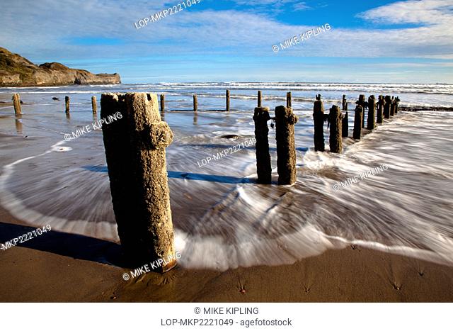 England, North Yorkshire, Sandsend. Waves from the North sea washing onto the shore around Groynes on Sandsend beach near Whitby on the North Yorkshire Coast