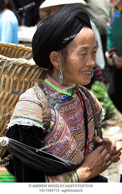 Woman with shoulder basket Bac Ha hilltribe market known for colourful Flower Hmong traders north Vietnam