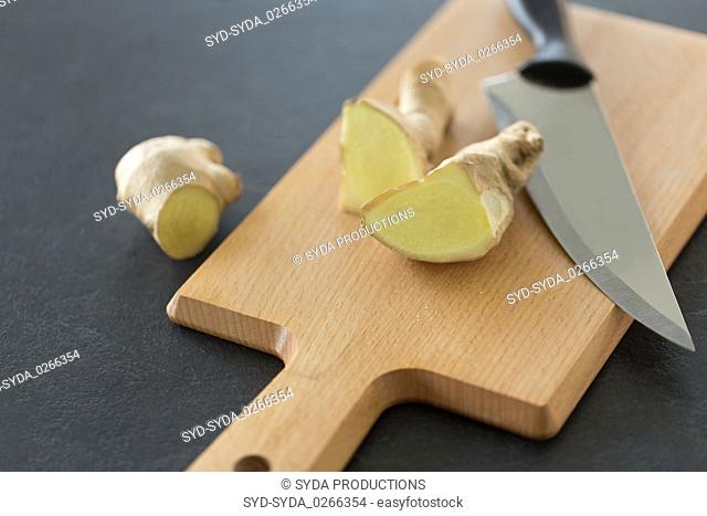 close up of ginger root and knife on cutting board