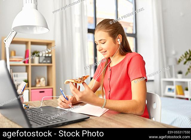 student girl in earphones with pizza at home