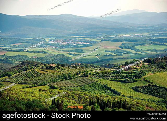 Panoramic view of fields, hills and trees at sunset in the Tuscan countryside, a gorgeous and traditional region in the center of the Italian Peninsula