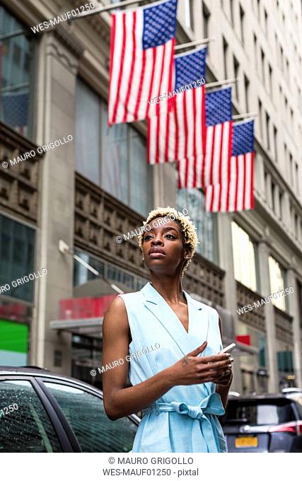 USA, New York, young blonde african-american woman with smartphone