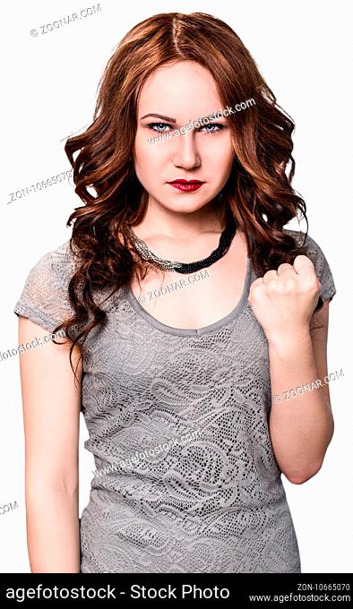 Young angry woman shows threaten fist on the white background