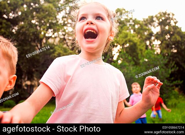 Happy kids playing on nature on a children's birthday party in summer