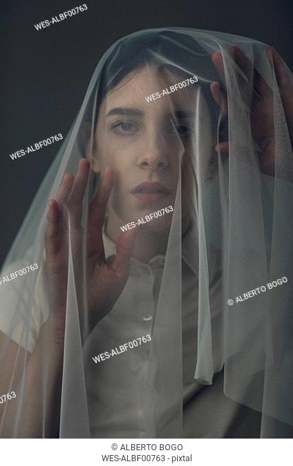 Melancholic woman under a veil
