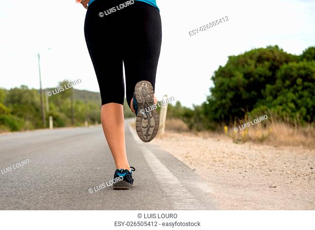 Woman's legs running outdoors at sunset hour